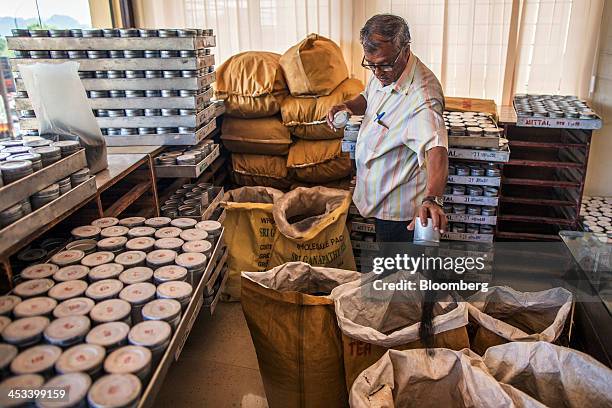 An employee sorts canisters of tea samples at the Santosh Tea Industries Pvt. Factory in Coonoor, Tamil Nadu, India, on Saturday, Nov. 30, 2013....