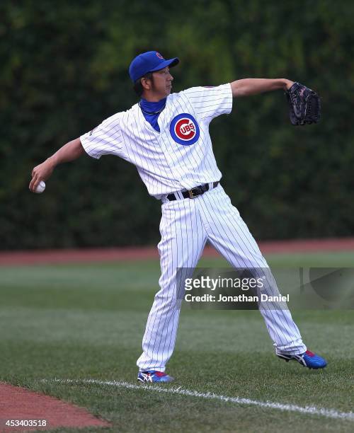 Kyuji Fujikawa of the Chicago Cubs plays catch with an outfielder during a game against the Tampa Bay Rays at Wrigley Field on August 9, 2014 in...