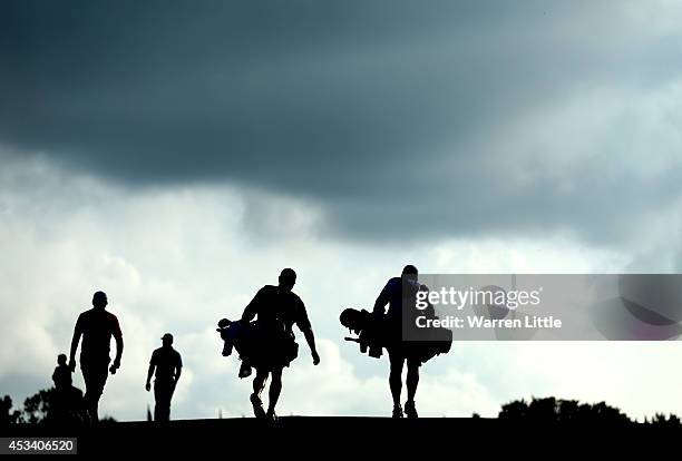 Rory McIlroy of Northern Ireland, Jason Day of Australia, caddie J.P. Fitzgerald and caddie Colin Swatton walk up the 17th hole during the third...