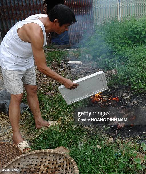 This picture taken on August 23, 2013 shows Thanh , owner of a rat restaurant, roasting rats in Dan Phuong on the outskirts of Hanoi. In somes areas...