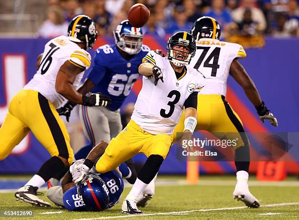 Quarterback Landry Jones of the Pittsburgh Steelers makes a throw as he is tackled by defensive end Damontre Moore of the New York Giants during a...