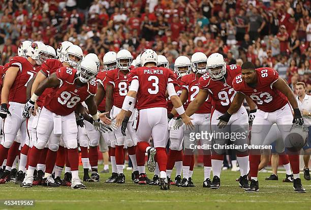Quarterback Carson Palmer of the Arizona Cardinals high-fives defensive ends Frostee Rucker and Calais Campbell as he is introduced to the preseason...