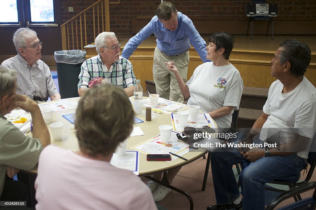 Colorado Gov. John Hickenlooper (D) talks with people at the Aurora Seniors Center