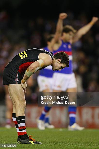 Lenny Hayes of the Saints reacts after defeat as Will Minson of the Bulldogs celebrates victory on the siren during the round 20 AFL match between...