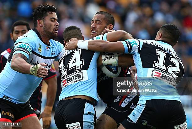 Suaia Matagi of the Warriors is wrapped up by the Sharks defense during the round 22 NRL match between the New Zealand Warriors and the Cronulla...