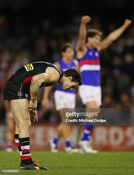 Lenny Hayes of the Saints reacts after defeat as Will Minson of the Bulldogs celebrates victory on the siren during the round 20 AFL match between...
