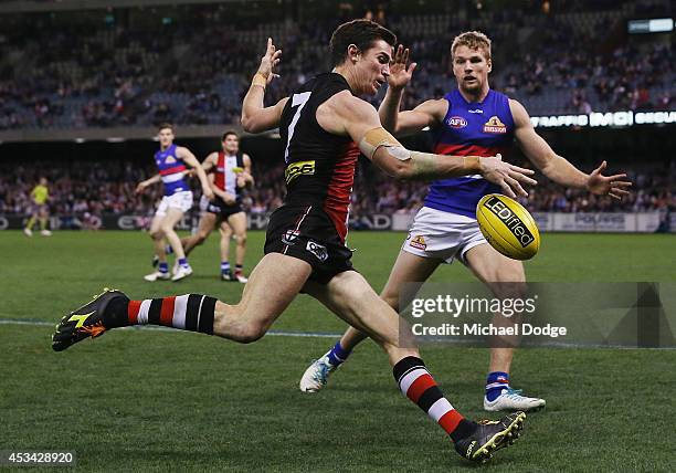 Lenny Hayes of the Saints kicks the ball past Jake Stringer of the Bulldogs during the round 20 AFL match between the St Kilda Saints and the Western...