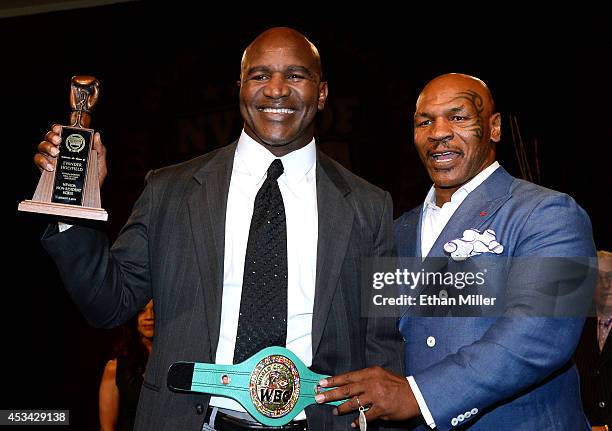 Former boxer Evander Holyfield is inducted into the Nevada Boxing Hall of Fame by former boxer Mike Tyson at the second annual induction gala at the...