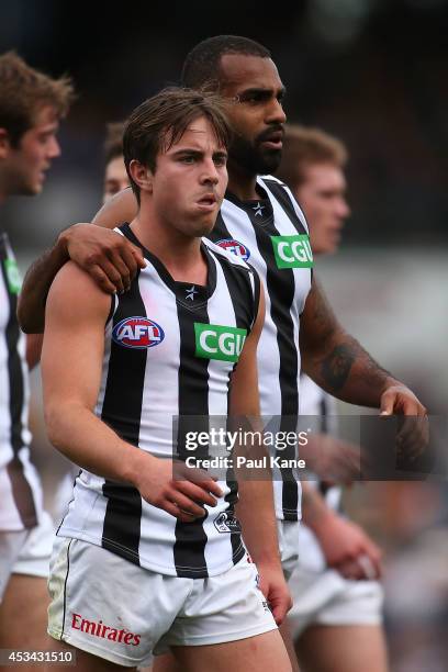 Ben Kennedy and Heritier Lumumba of the Magpies lead the team from the field at the half time break during the round 20 AFL match between the West...