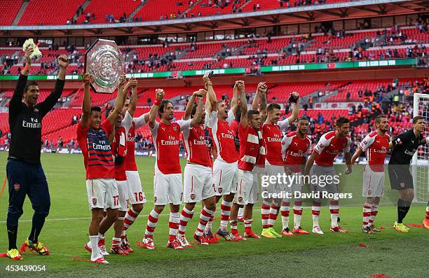 Alexis Sanchez of Arsenal holds up the trophy next to team-mates after the FA Community Shield match between Manchester City and Arsenal at Wembley...