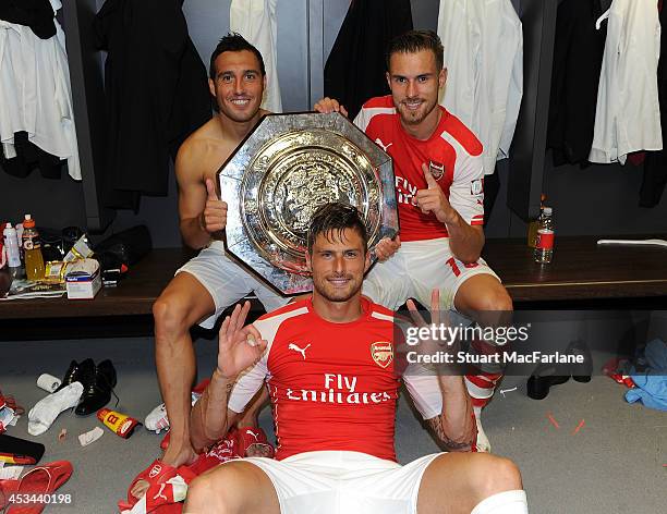 Arsenal goalscorers Santi Cazorla, Olivier Giroud and Aaron Ramsey pose with the FA Community Shield after the FA Community Shield match between...