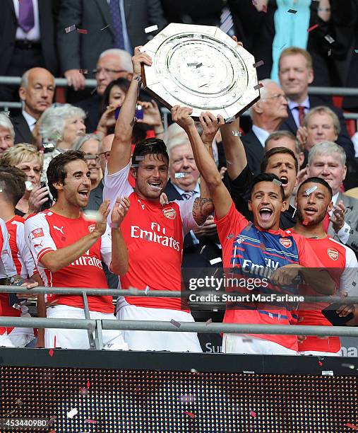 Mathieu Flamini, Olivier Giroud and Alexis Sanchez lift the Community Shield after the match between Arsenal and Manchester City at Wembley Stadium...