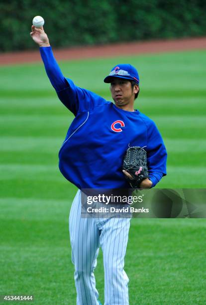 Kyuji Fujikawa of the Chicago Cubs warms up in the outfield before the game against the Tampa Bay Rays on August 10, 2014 at Wrigley Field in...