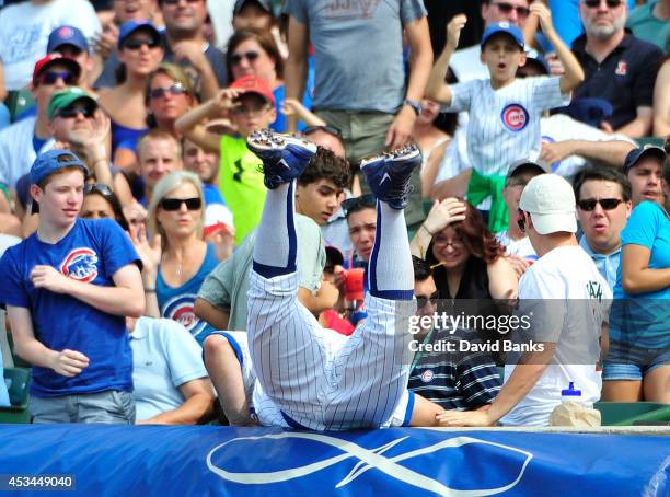 Anthony Rizzo of the Chicago Cubs dives in the stands for a foul ball hit by Brandon Guyer of the Tampa Bay Rays during the seventh inning on August...