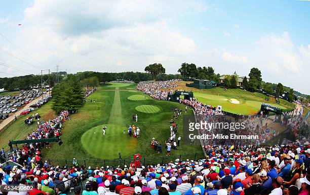 Rory McIlroy of Northern Ireland hits his tee shot on the first hole as a gallery of fans look on during the final round of the 96th PGA Championship...