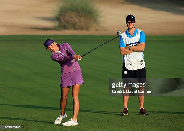 Danielle Montgomery of England plays her second shot on the par 5, 10th hole watched by her caddie John Peers of Australia the tennis player during...