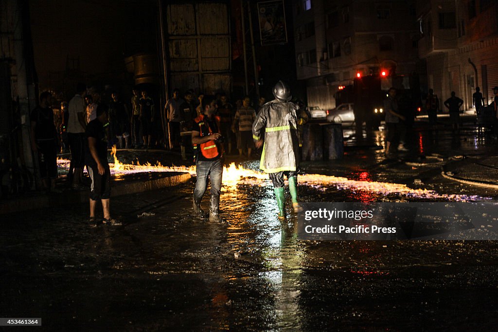 Palestinian firefighters try to extinguish a fire in a...