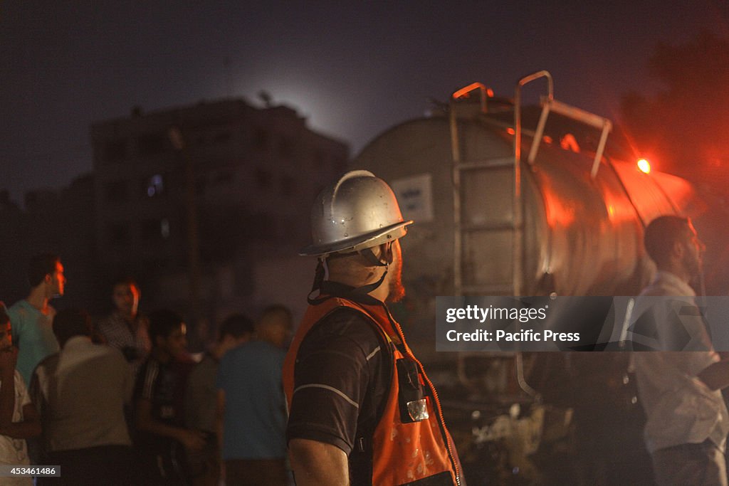 Palestinian firefighters try to extinguish a fire in a...