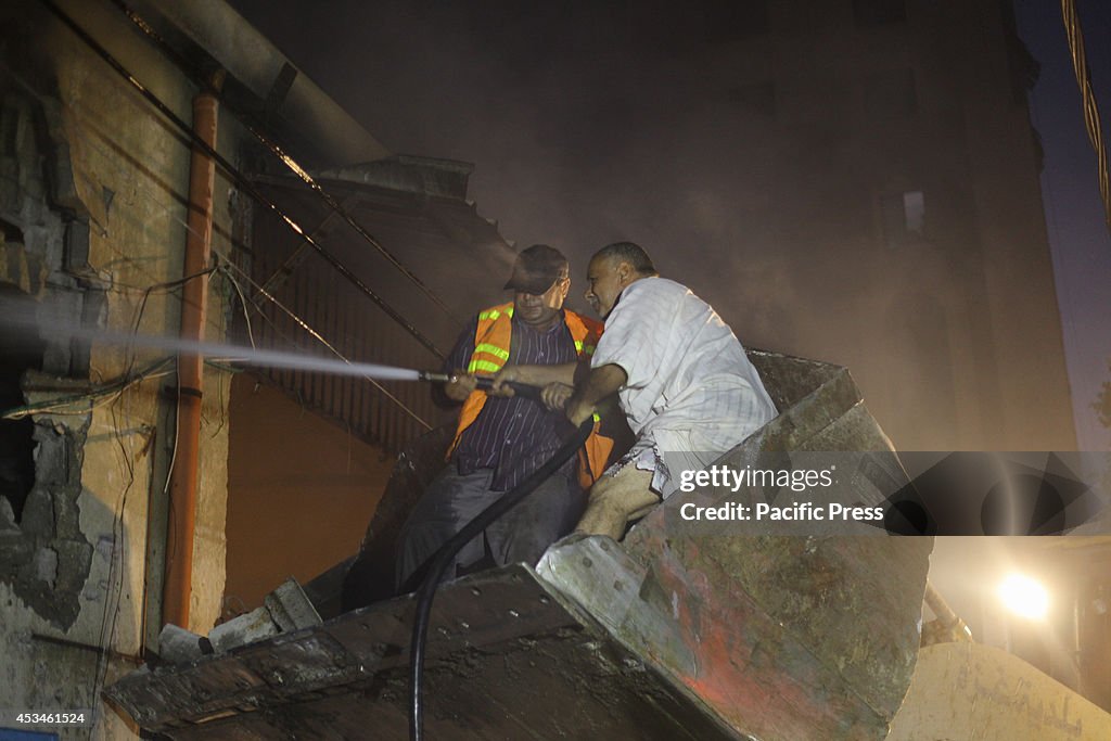 Palestinian firefighters try to extinguish a fire in a...