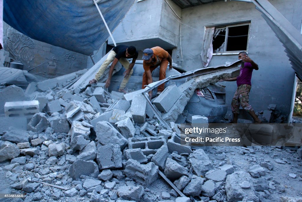 Palestinians inspect a house after it was hit by an Israeli...