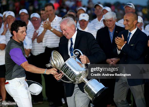 Rory McIlroy of Northern Ireland catches the lid of the Wanamaker trophy as PGA of America President, Ted Bishop, holds the trophy after his...
