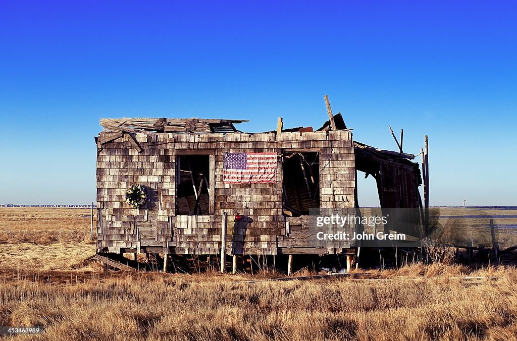 Ruined and abondoned shack with American flag and Christmas...