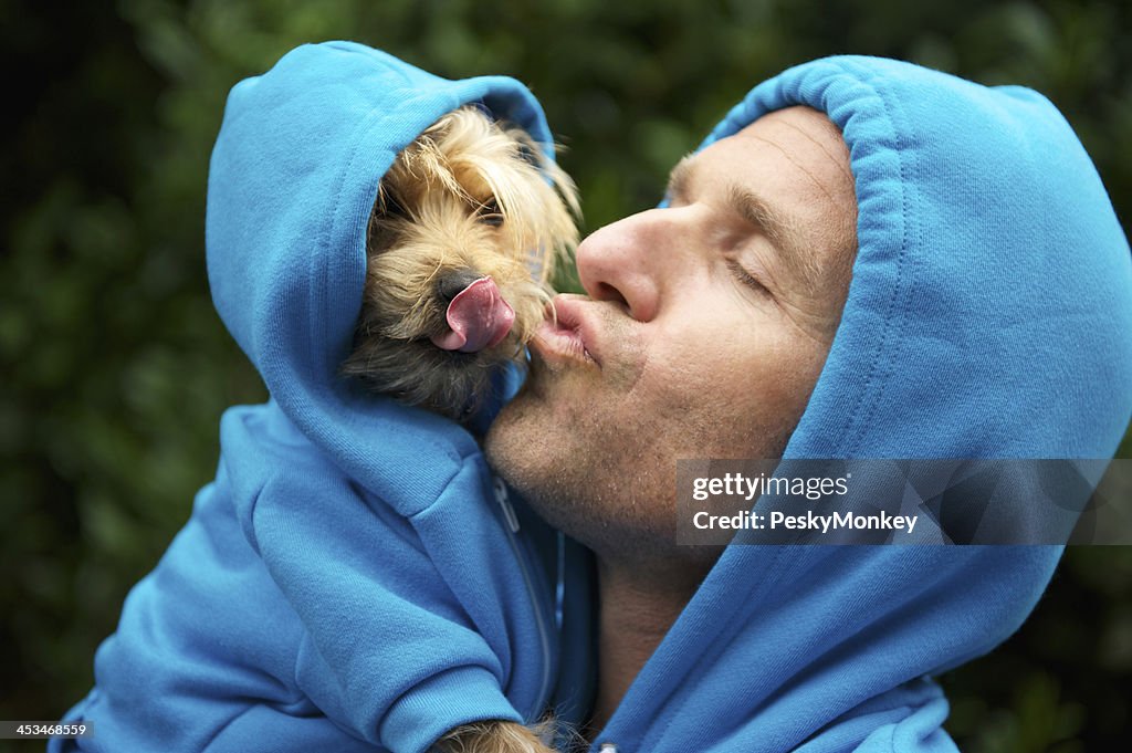 Man Kissing Best Friend Dog Matching Blue Hoodies at Park