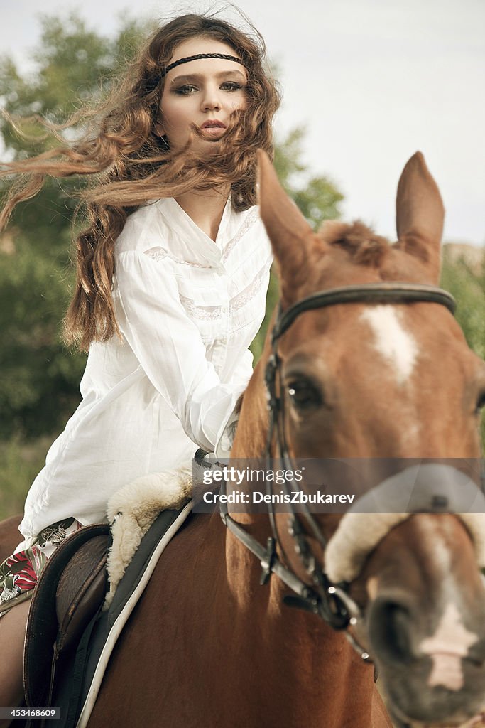 Jeune femme chevauchant un cheval