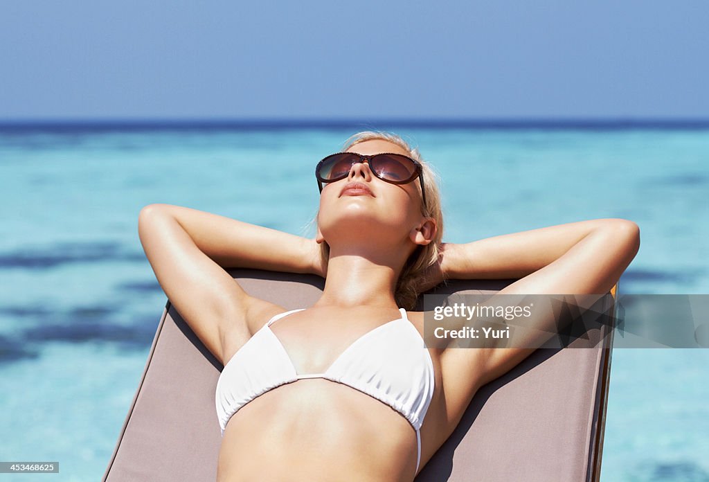 Young pretty girl sunbathing by the seaside