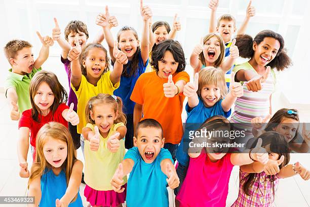 group of children showing thumbs up. - children only stock pictures, royalty-free photos & images