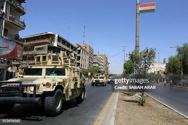 Iraqi army armoured vehicles patrol a street in Baghdad's commercial district of Karrada on August 11, 2014 as security measures have been reinforced...