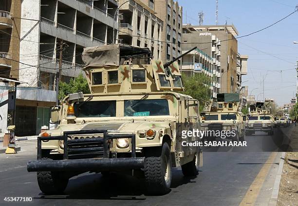Iraqi army armoured vehicles patrol a street in Baghdad's commercial district of Karrada on August 11, 2014 as security measures have been reinforced...