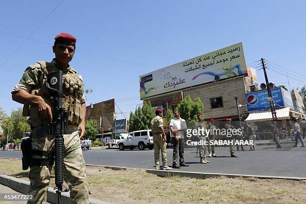 Iraqi security forces patrol a street in Baghdad's commercial district of Karrada on August 11, 2014 as security measures have been reinforced across...