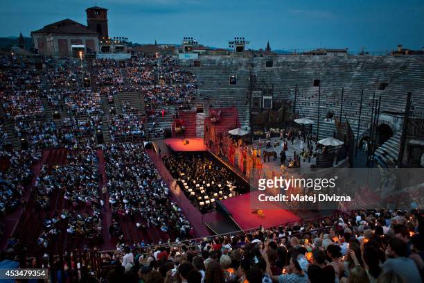 Visitors are sitting on the stone steps in the Arena of Verona on July 25, 2014 in Verona, Italy. The famous Arena di Verona is popular for the...