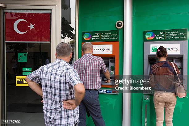 The cresent and star symbol of the Turkish national flag hangs from a window blind beside automated teller machines operated by Turk Ekonomi Bankasi...