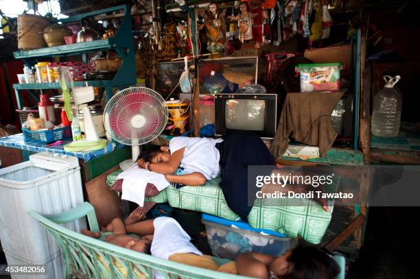 Family sleeps at a bench which also doubles as a market stall on August 11, 2014 in Manila, Philippines. The Philippines has one of the fastest...