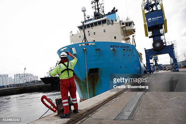 Peterson Ltd. Employee throws off a mooring line as the anchor handling tug supply ship Maersk Assister, operated by A.P. Moeller-Maersk A/S,...