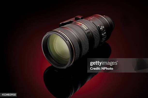 Nikon AF-S 70-200mm f/4G ED VR telephoto lens photographed on a red background, taken on November 18, 2013.