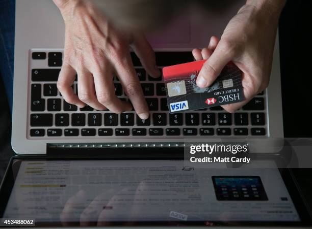 In this photo illustration a woman uses a credit card to buy something online on August 11, 2014 in Bristol, United Kingdom. This week marks the 20th...