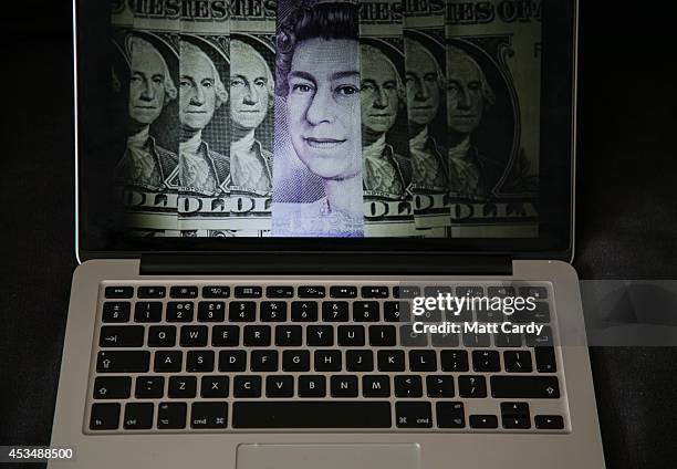 In this photo illustration a laptop displays a image of dollars and sterling notes on August 11, 2014 in Bristol, United Kingdom. This week marks the...