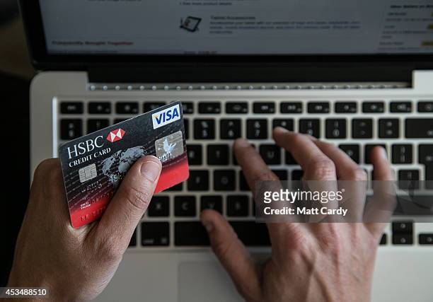 In this photo illustration a woman uses a credit card to buy something online on August 11, 2014 in Bristol, United Kingdom. This week marks the 20th...