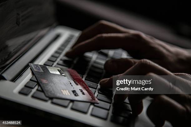 In this photo illustration a woman uses a credit card to buy something online on August 11, 2014 in Bristol, United Kingdom. This week marks the 20th...