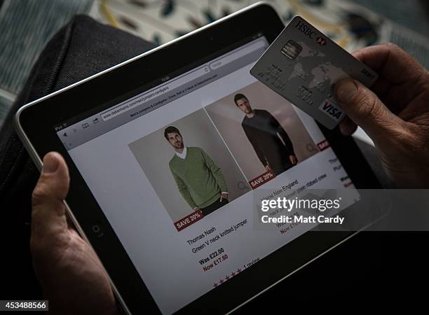 In this photo illustration a man uses a credit card to buy something online on August 11, 2014 in Bristol, United Kingdom. This week marks the 20th...