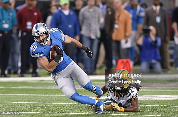 Kris Durham of the Detroit Lions catches the pass for a first down as Davon House of the Green Bay Packers makes the tackle during the first quarter...