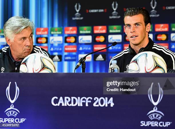 In this handout image provided by UEFA, Real Madrid Manager Carlo Ancelotti listens to Gareth Bale of Real Madrid during the Real Madrid press...