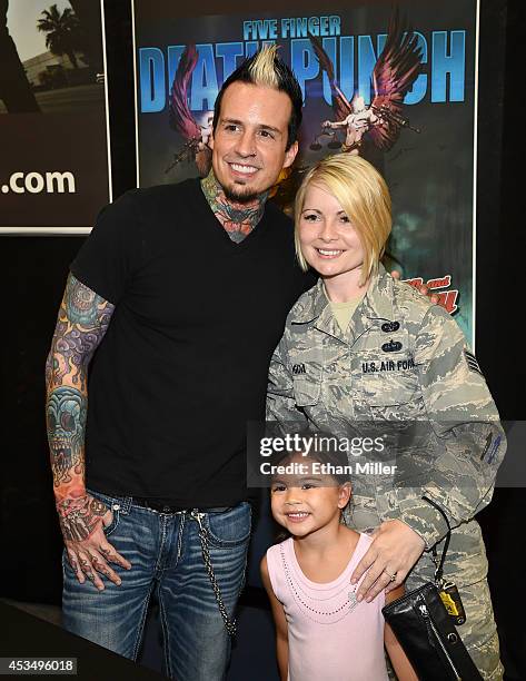 Drummer Jeremy Spencer of Five Finger Death Punch poses for a photo with Staff Sgt. Nicole Igoa and her daughter Kalena Igoa at Nellis Air Force Base...