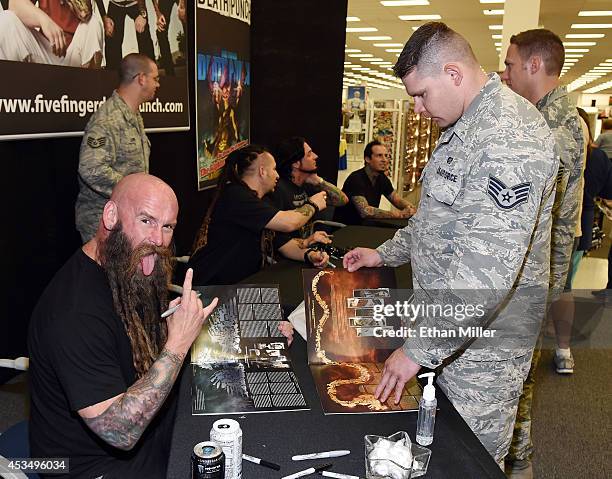 Bassist Chris Kael of Five Finger Death Punch jokes around as he signs autographs for Staff Sgt. Anthony Coalwell at Nellis Air Force Base as the...