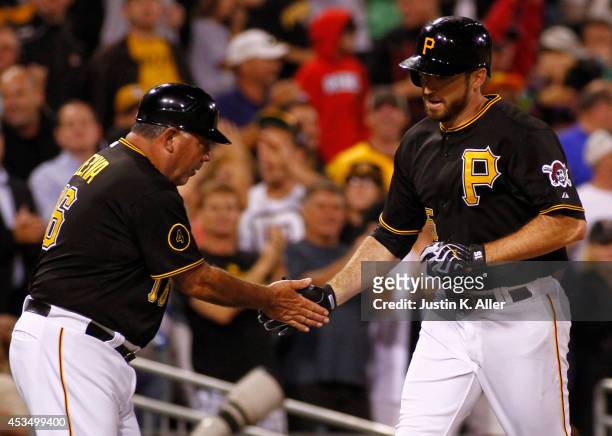 Ike Davis of the Pittsburgh Pirates celebrates with third base coach Nick Leyva after hitting a solo home run in the sixth inning against the Detroit...