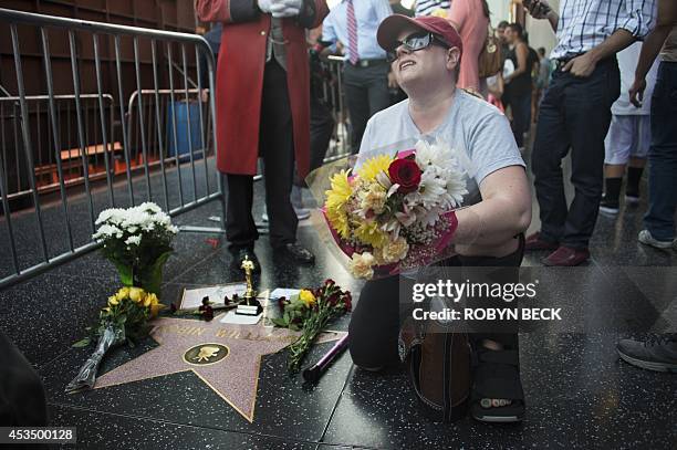 Woman grieves beside Robin Williams' star on the Hollywood Walk of Fame is seen, August 11 in Hollywood, California. Academy Award-winning actor and...