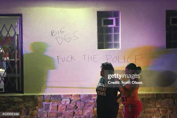 Residents gather at a police line as the neighborhood is locked down following skirmishes on August 11, 2014 in Ferguson, Missouri. Police responded...